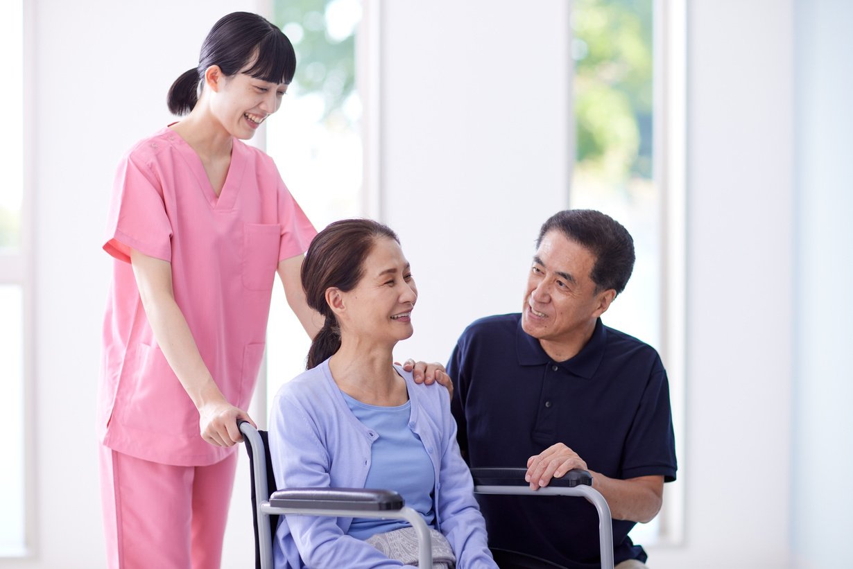 Supportive Caregivers with an Elderly Woman in a Wheelchair